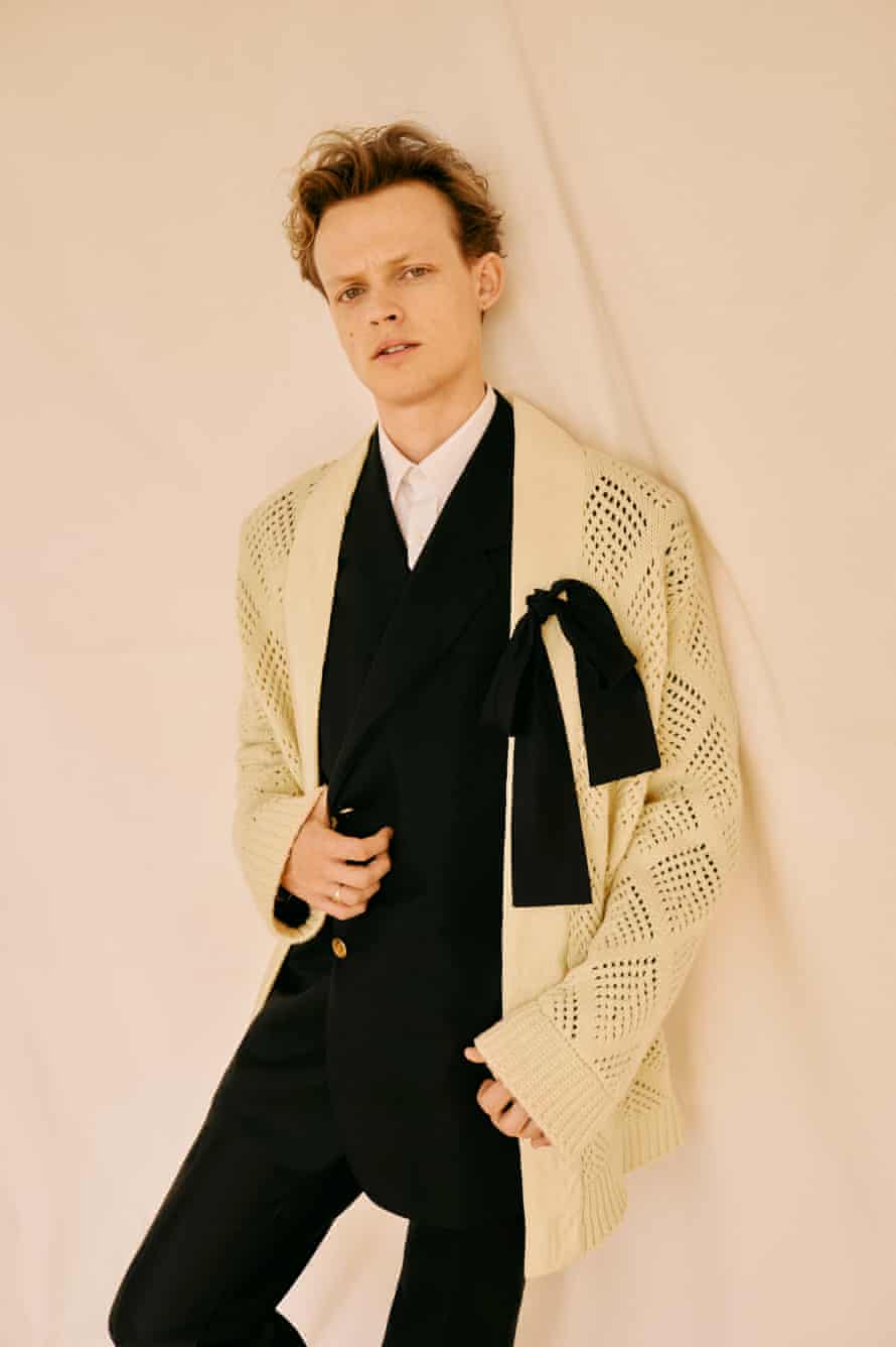 Man of the moment: Anson Boon wears black suit, white shirt, lemon blanket cardigan with bow, all by dunhill.com.