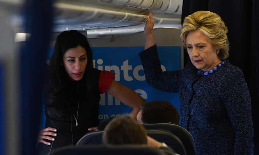 Hillary Clinton talks to unit   arsenic  Abedin listens onboard their run  plane, successful  October 2016.