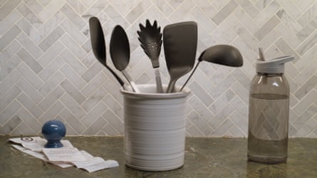 Kitchen jar with plastic utensils (spoon, spatula, etc) and a plastic water bottle
