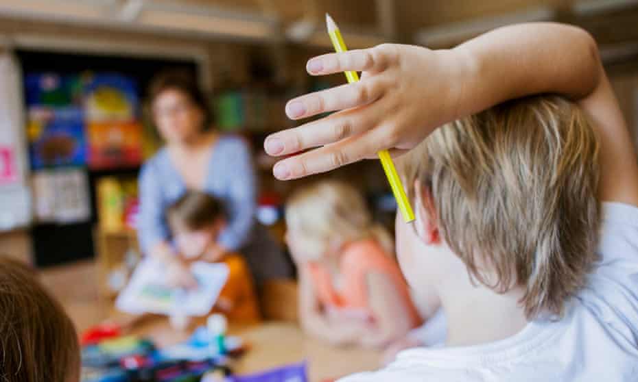 Boy raises his hand in a classroom