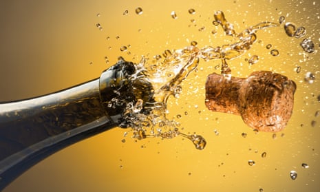 A cork explodes from a newly opened bottle of sparkling wine