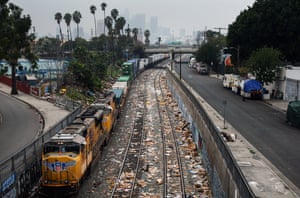 A Union Pacific freight train passes along a section of tracks littered with debris from packages stolen from cargo containers stacked on rail cars in Los Angeles.