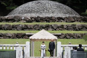 Princess Aiko giving a speech on a small platform under a tented roof, with the large stone dome of the tomb behind her