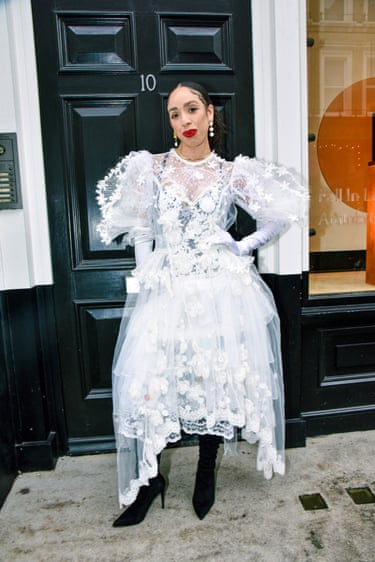 A person wearing a white dress and black boots