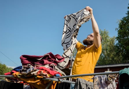 A man in a yellow T-shirt folding laundry