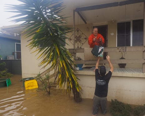 A resident receives supplies during flooding in North Shore, north of Port Macquarie, on Friday