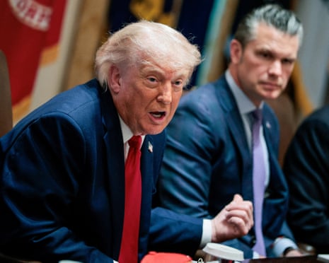 Donald Trump gestures while speaking at a meeting table