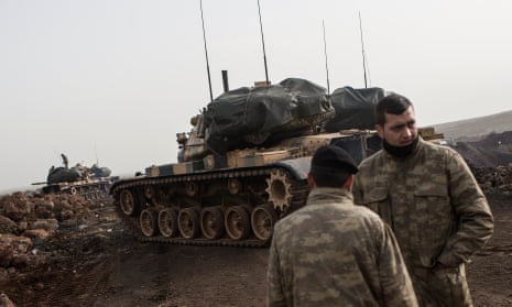 Turkish soldiers prepare their tanks before crossing the Syrian-Turkish border at Hatay.