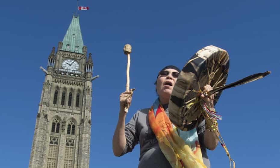Marcia Brown Martel, who was taken from her home as a child and adopted by non-indigenous parents, sings outside the parliament buildings in Ottawa.