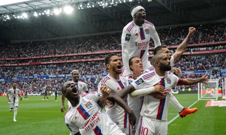 Lyon’s Alexandre Lacazette (No 10) celebrates with his teammates after scoring a late penalty against Montpellier, his fourth goal of a dramatic game