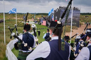President Donald Trump, followed by a bagpiper band, raises his fist