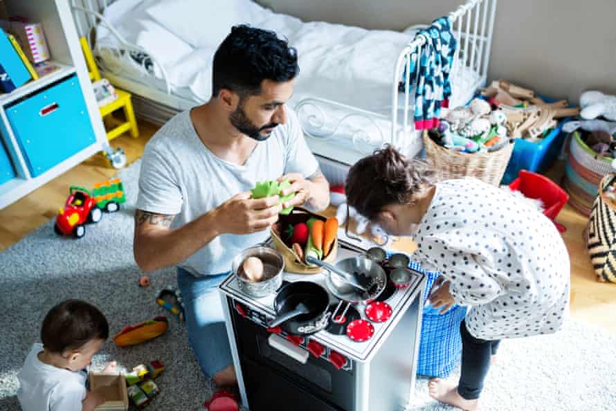 High angle view of father and sons playing with toy kitchen in bedroom at home