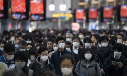 Commuters make their way to work in Tokyo on 26 March