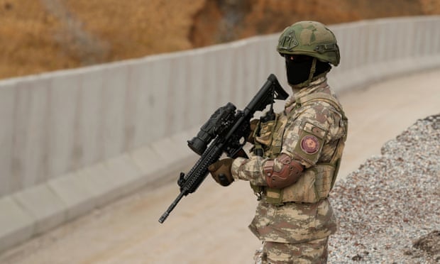 A Turkish commando stands guard near a wall on the border line between Turkey and Iran in Van province.