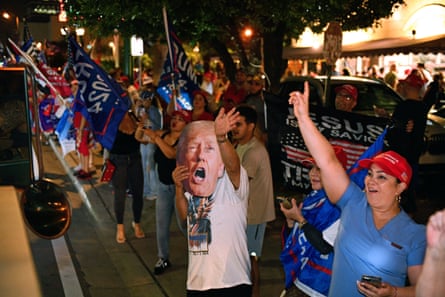 crowd of people wave flags and raise hands in air