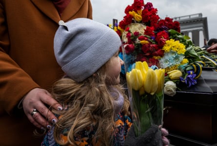 A girl brings flowers to the funeral of young fallen volunteer fighters who were killed on a sabotage mission in the Russian district of Bryansk, March 2023