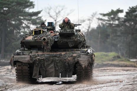 Pistorius sits next to a German soldier driving a Leopard 2 tank in Augustdorf
