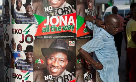 A man stands in front of electoral campaign posters in Lagos, Nigeria, in 2015