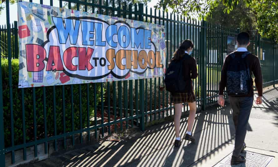 Students walking past a school fence