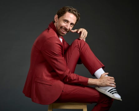 Eric Lampaert sits in profile with his head turned towards the camera and his foot resting on his knee