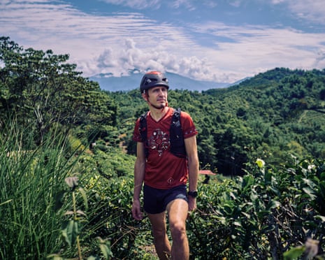 Peter Novotny wearing shorts, helmet and rucksack in a verdant mountainous landscape
