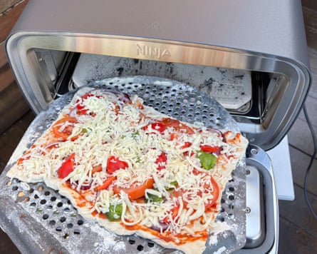 An uncooked pizza ready to go into the Ninja Artisan pizza oven.