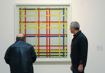 Two men inspect the painting New York City I by Piet Mondrian featured in the Piet Mondrian - Vom Abbild zum Bild exhibition at Museum Ludwig in Cologne, Germany in 2007.