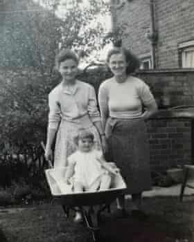 Ros Coffey, pictured in a wheelbarrow, with her sister Annette and her mum.