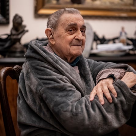 Victor Pitigoi, an elderly man with short grey hair, wearing a grey dressing gown, sitting at a table.