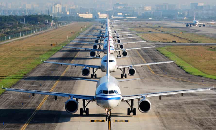 Many airplanes are in line on the runway waiting for take off