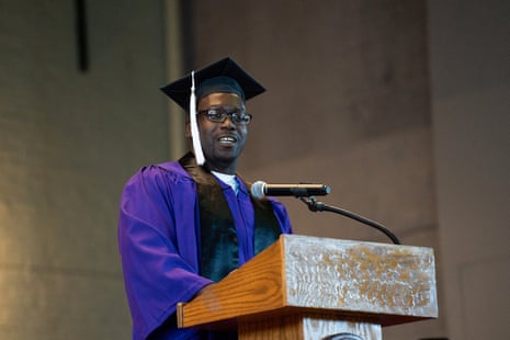 Man in cap and gown behind lectern