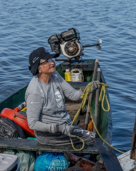A woman on a boat wearing gloves and protective eyewear.