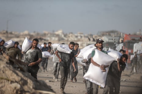 Palestinians receive aid supplies after trucks sent by the United Nations reached warehouses in the north of Gaza City, in June.