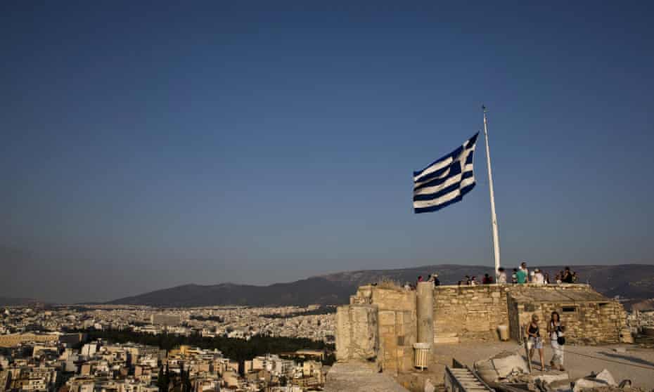 Greek flag flutters in the wind as tourists visit the archaeological site of the Acropolis hill in Athens, GreeceA Greek flag flutters in the wind as tourists visit the archaeological site of the Acropolis hill in Athens, Greece July 26, 2015. REUTERS/Ronen Zvulun/File Photo