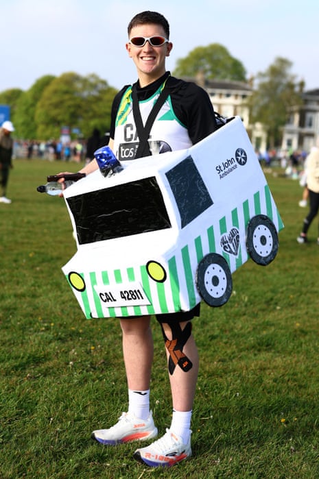 A fun-runner wearing a St John Ambulance costume poses at the start before competing in the London Marathon