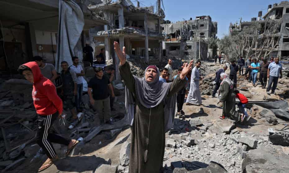 People assess the damage caused by Israeli airstrikes in Beit Hanun, in the northern Gaza Strip