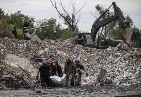 Firefighters remove a body from debris of a building as search and rescue operations continue after Russian airstrikes hit residential areas in Chasiv Yar, Donetsk, Ukraine on July 11.