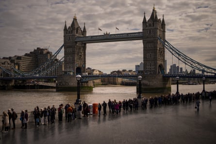 People queue along the Thames near Tower Bridge