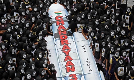 Students with painted faces surround a replica of the Chandrayaan-3 spacecraft in Chennai