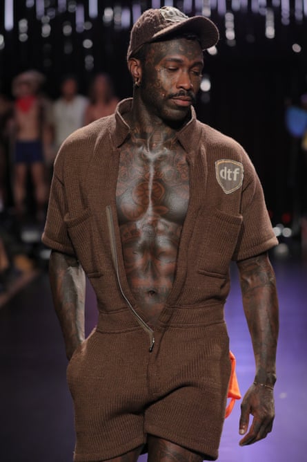 A model wears a knitted delivery-worker uniform and cap