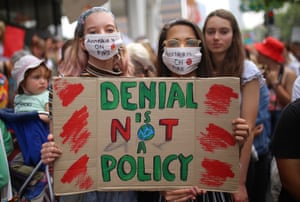 Student activists from School Strike for Climate Australia hold a sign saying 'Denial if not a policy'