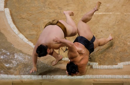 Osho (left) and Hakuoho (right) throw each other out of the ring at exactly the same time. After a judges’ consultation they decided it was a tie and ordered an immediate rematch