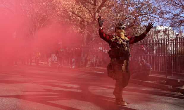 A gun rights advocate wearing body armor and carrying firearms sets off a smoke bomb at the conclusion of a rally near the state capitol building in Richmond, Virginia, on 20 January. 