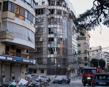 Debris covers a street beside an apartment building hit by an Israeli airstrike in Dahieh.