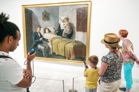 A small boy listens to an audio guide at Barcelona’s Museu Picasso, in front of the artist’s teenage painting Science and Charity, 1897.