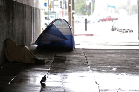 A homeless man huddles under a blanket in Los Angeles. 