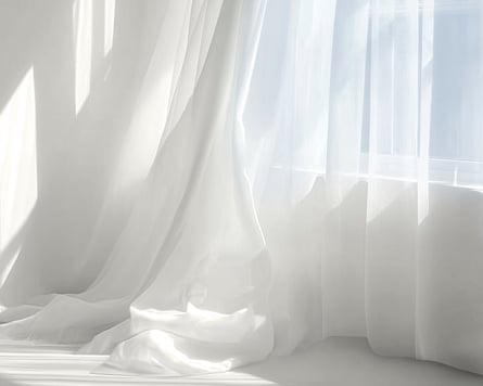 White curtains on a window, in Pantone’s cloud dancer colour