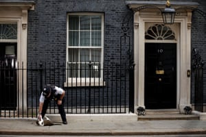 London, UK. A police officer strokes Larry the cat outside 10 Downing Street, on the day that Prime Minister Boris Johnson faces PMQs after several Conservative MPs resign in protest at his leadership