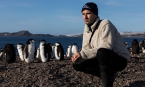 Michael Segalov, pictured on Barrientos Island, in the South Shetland Islands, with a group of penguins behind him