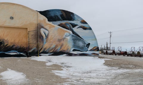 A hangar-like building with a picture of a polar bear painted on the side